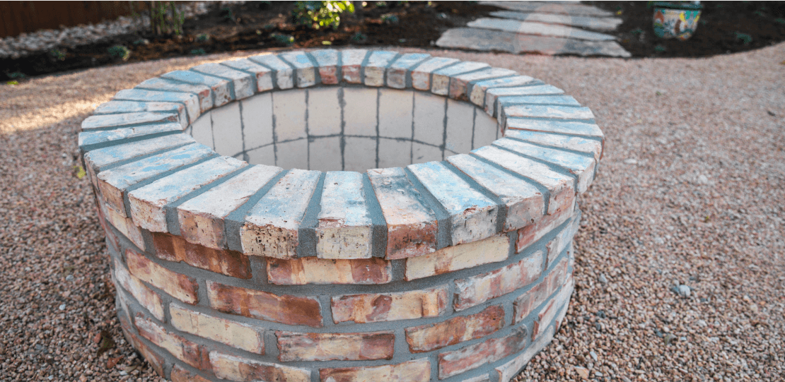 Close up of a round brick fire pit.