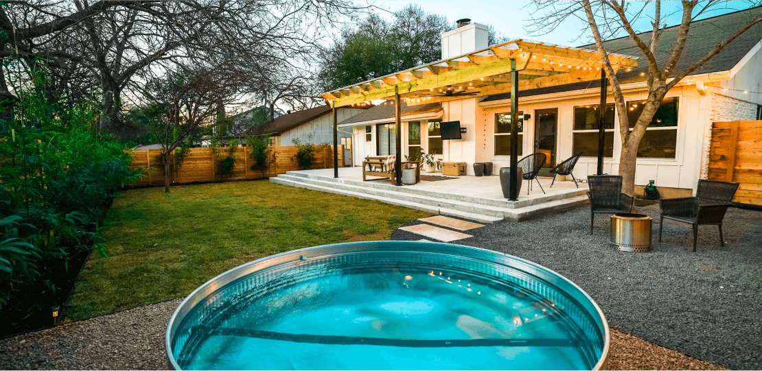A backyard with a small, above-ground pool, and a patio covered with a wooden pergola.