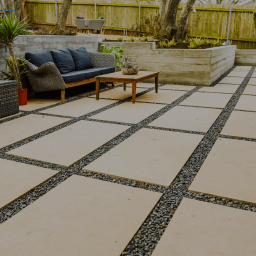 Smooth, rectangular pavers arranged in a grid surrounded by gravel.