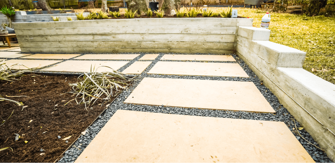 Smooth, rectangular pavers arranged in a path surrounded by gravel.