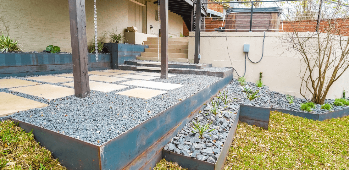 Metal structures containing gravel and stones arranged in a backyard.