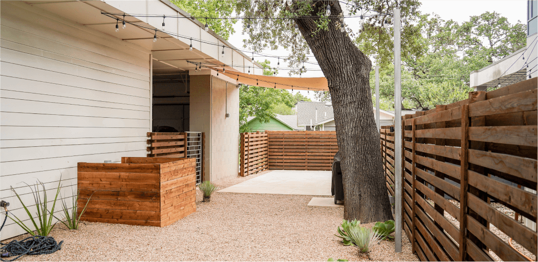 A wooden fence with horizontal slats enclosing a backyard.