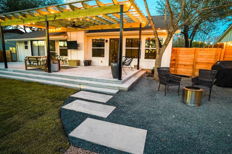 2 paved tiles on gravel leading to a patio area.