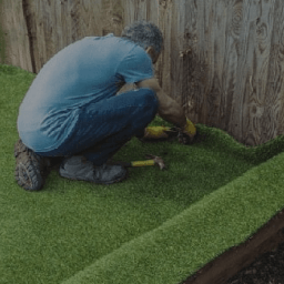Man installing turf in a yard.