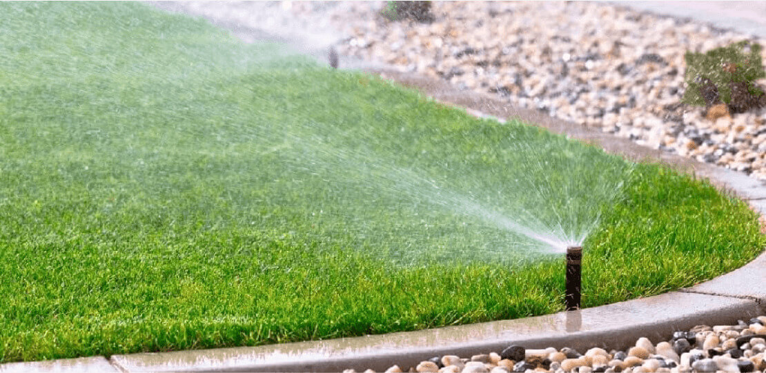 A sprinkler spraying water onto grass.