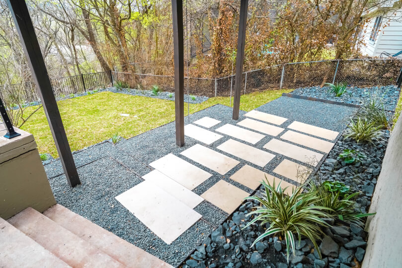 Lightly-colored rectangular pavers lined with grey pebbles.