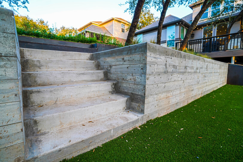 Close up of cement stairs with lush green grass leading to their base.
