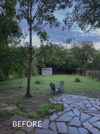 Large backyard with irregularly shaped stone tiles in a small area and grass in the rest of the yard. There are two outdoor chairs next to a thin tree. The word 'before' is overlaid atop the photo.