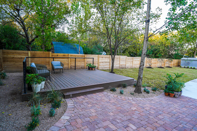 Red brick patch leading up to a dark wooden deck.