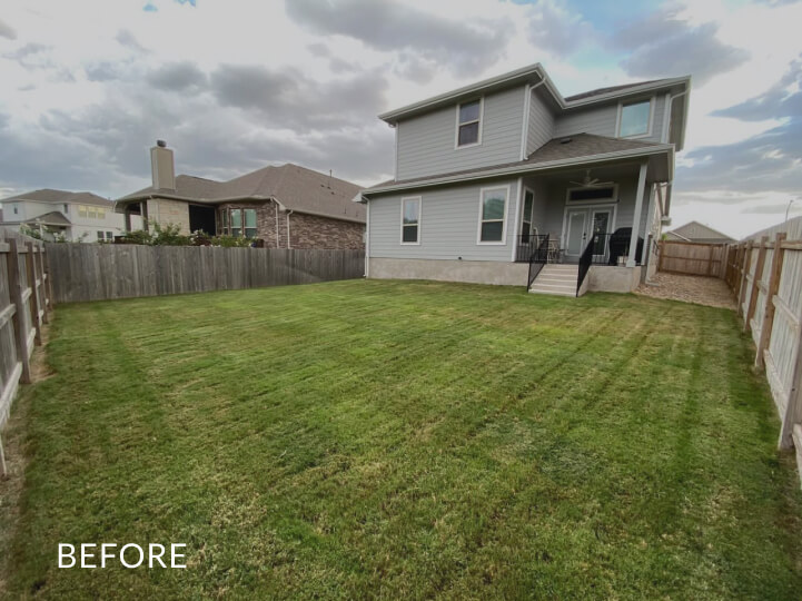 Mostly empty backyard with grass and a low wooden fence along the edge. The word 'before' is overlaid atop the photo.