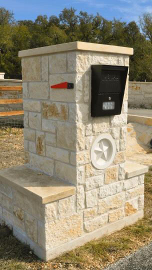 White stone front yard mailbox. There is a white star in the middle of the stone mailbox.