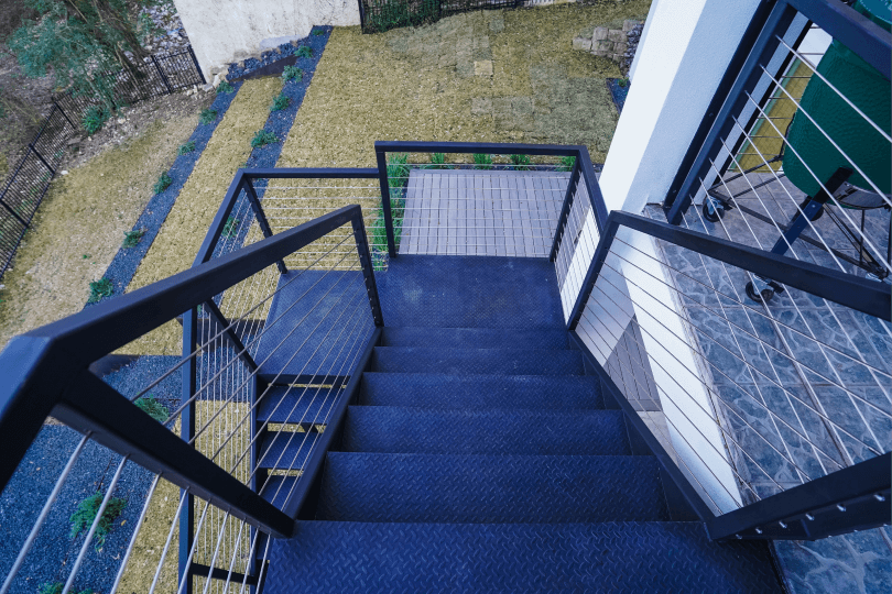 Stairs going down to a grassy backyard