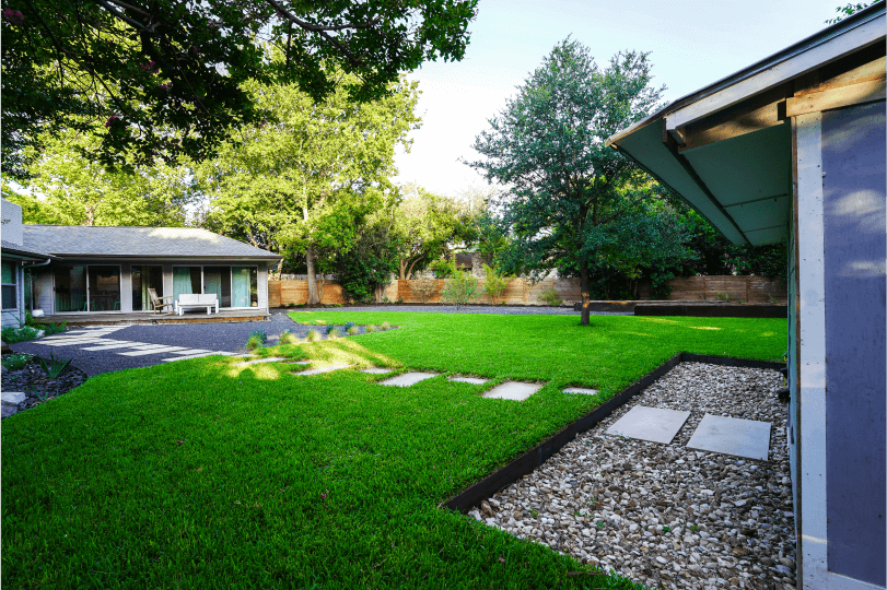 Green grass with a view of a house in the background
