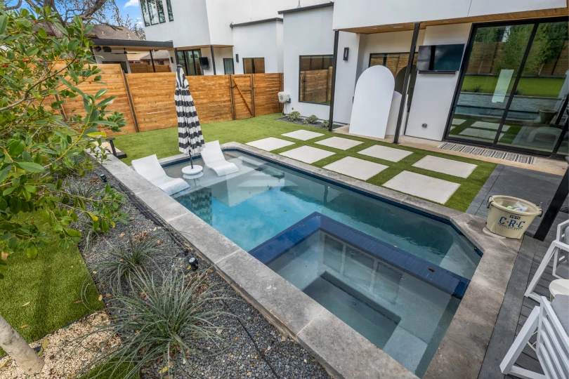 Backyard of a home in Rosedale with a swimming pool, a gravel bed with succulent plants, stone pavers, and a sitting area.