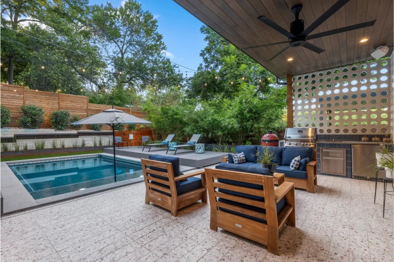 Cutters-Bellaire covered back porch with chairs and couch overlooking pool and cooking area